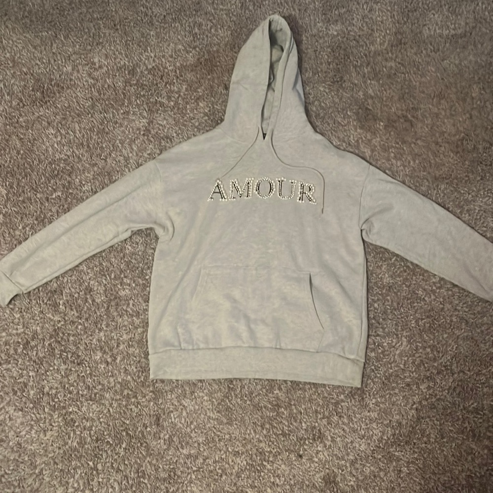 a grey hoodie with beading on the front that spells out "Amour" size M